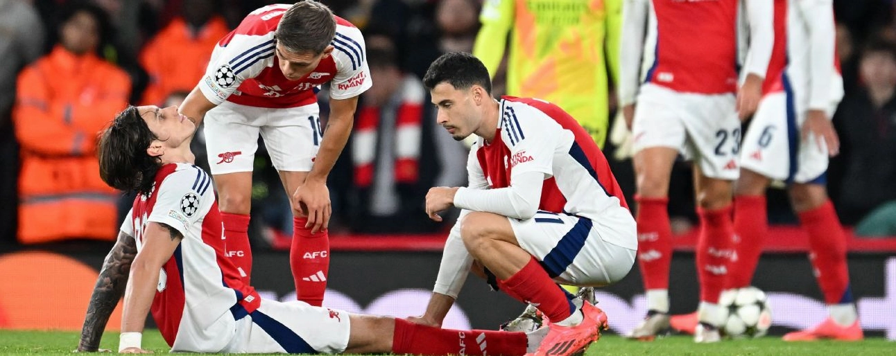 Riccardo Calafiori dính chấn thương và được đồng đội Leandro Trossard cùng Kai Havertz hỏi thăm trong trận đấu gặp Shakhtar Donetsk