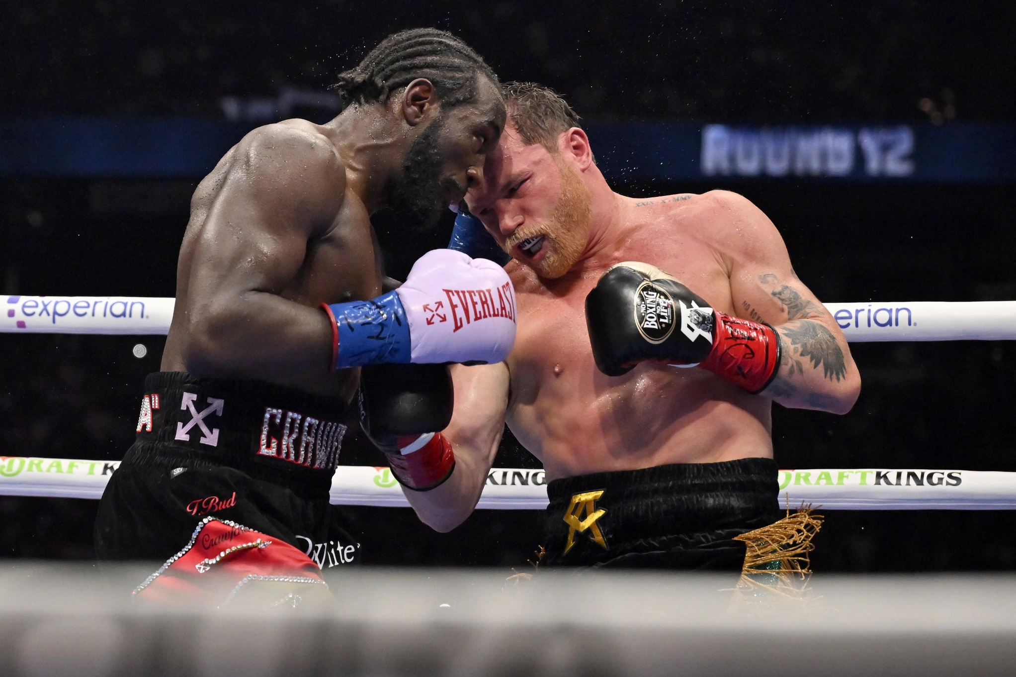 Terence Crawford and Canelo Alvarez intensely facing off in the center of the ring